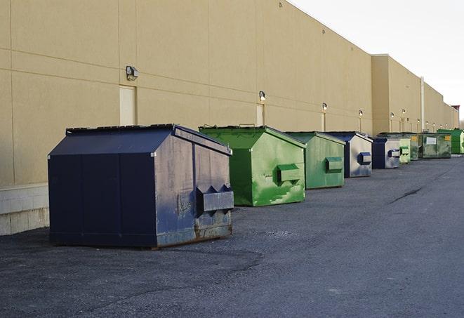 a construction worker disposing of debris into a dumpster in Carlton